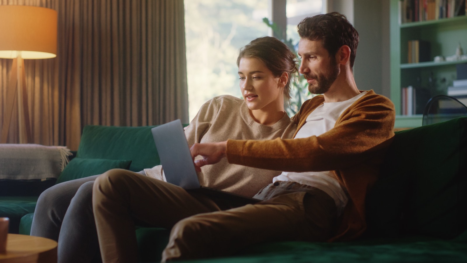 A couple on their couch planning together on a laptop